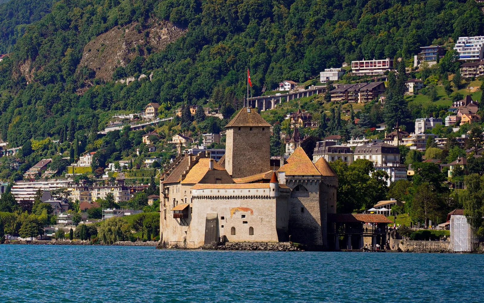 Chillon Castle beside Lake Geneva near Montreux, with the hillside behind it.