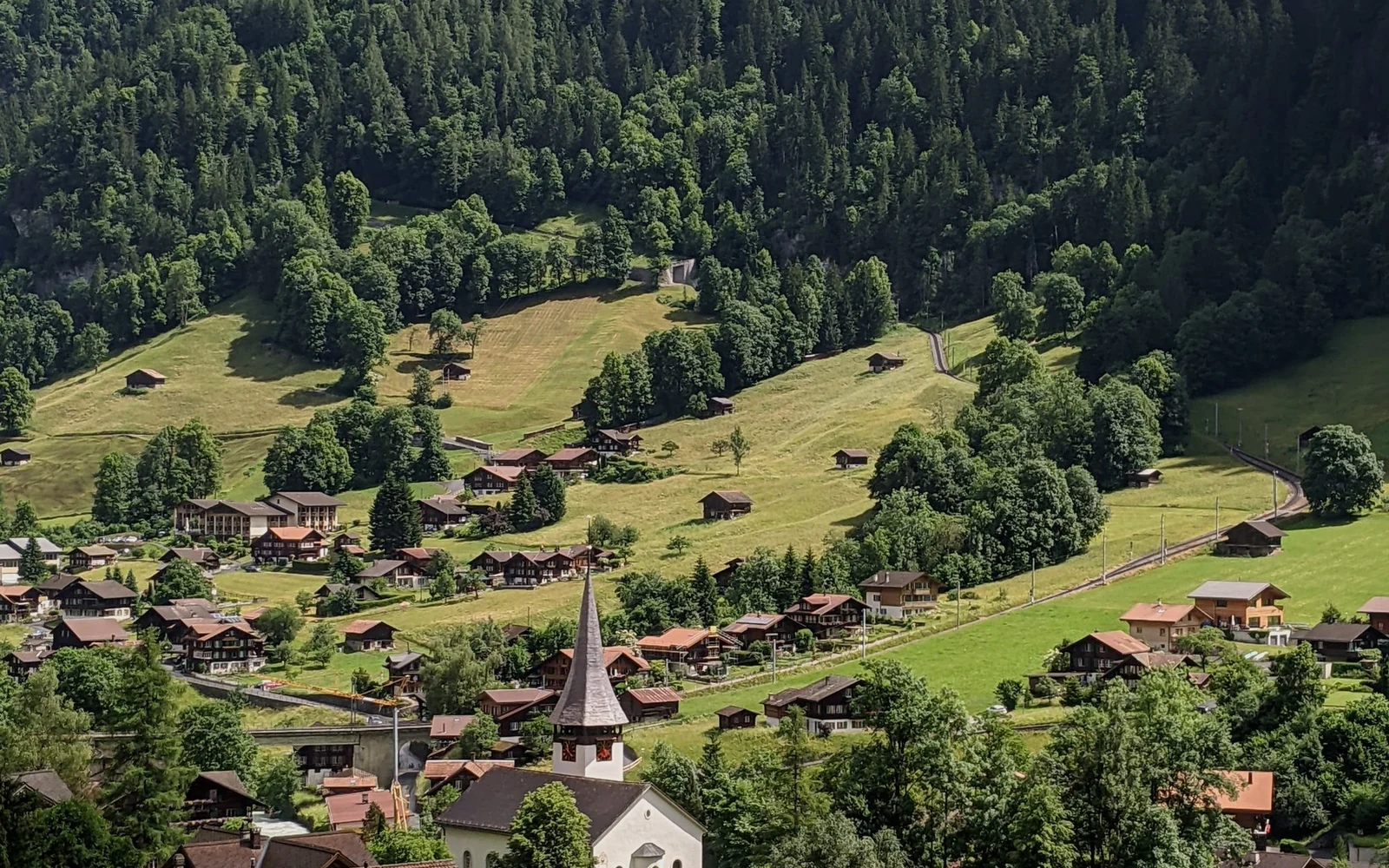 Village buildings and green slopes in the Lauterbrunnen valley, an optional outing from Interlaken.
