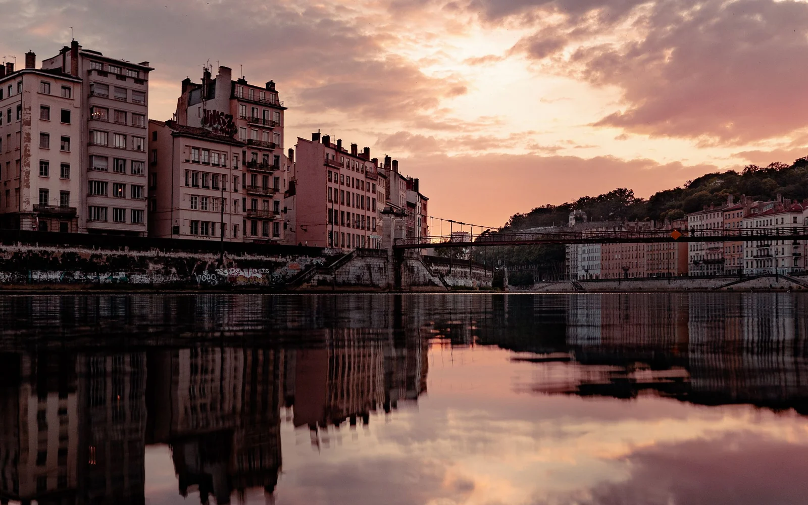 Lyon’s riverside buildings reflected in the water in the evening.