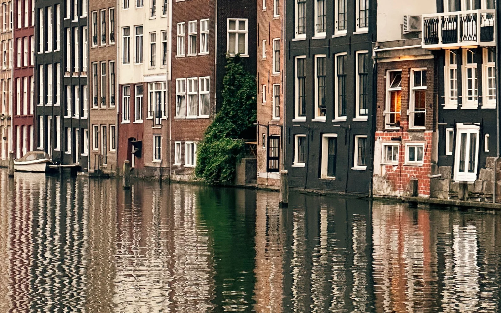 Traditional Amsterdam canal houses reflected in the water.