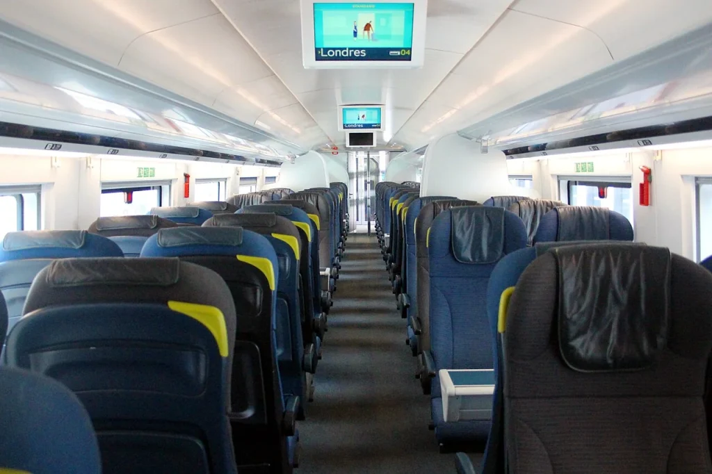 Rows of seats and the central aisle inside a Eurostar Class 374 Standard carriage.