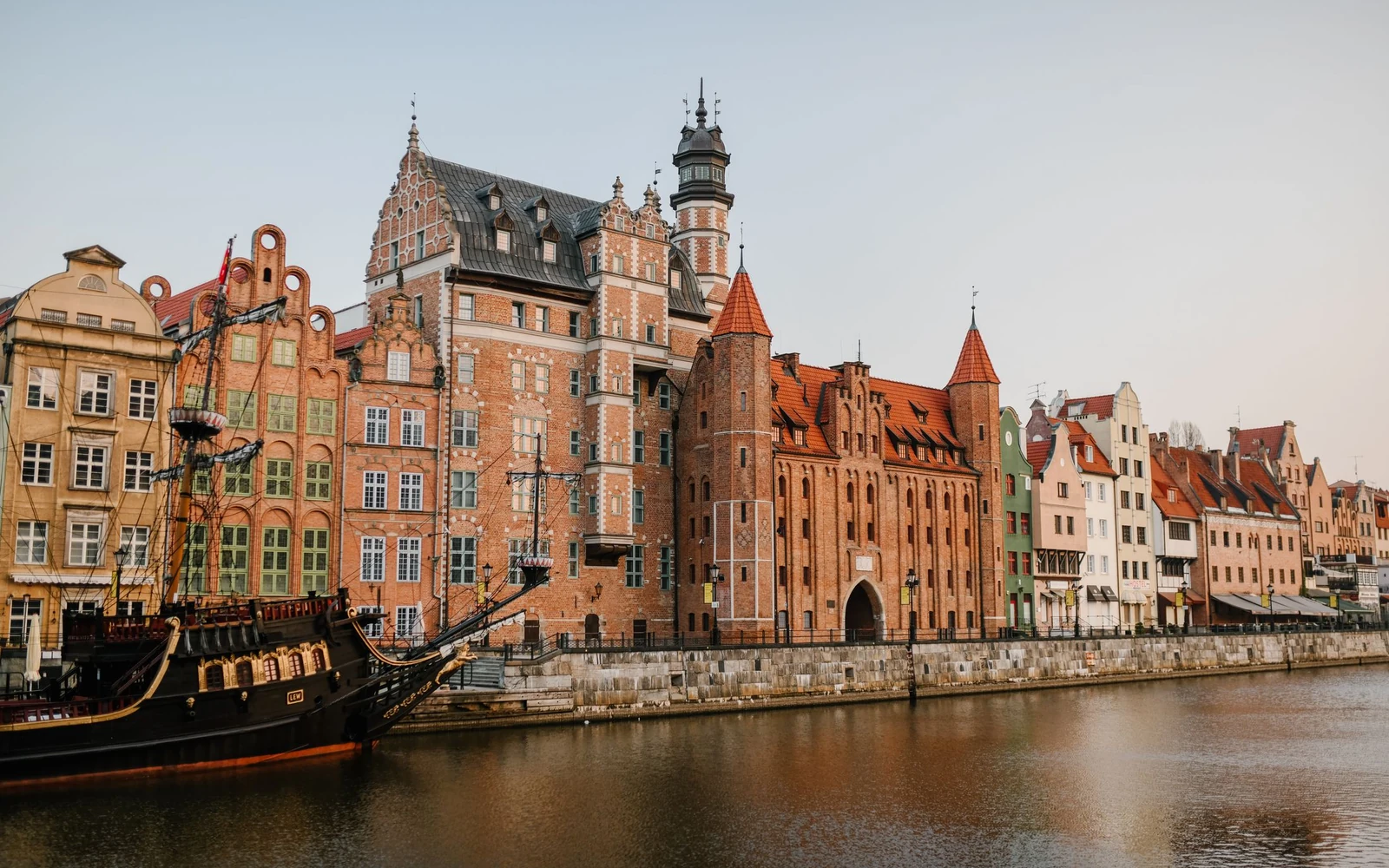 Historic buildings and boats along the Motława waterfront in Gdańsk.