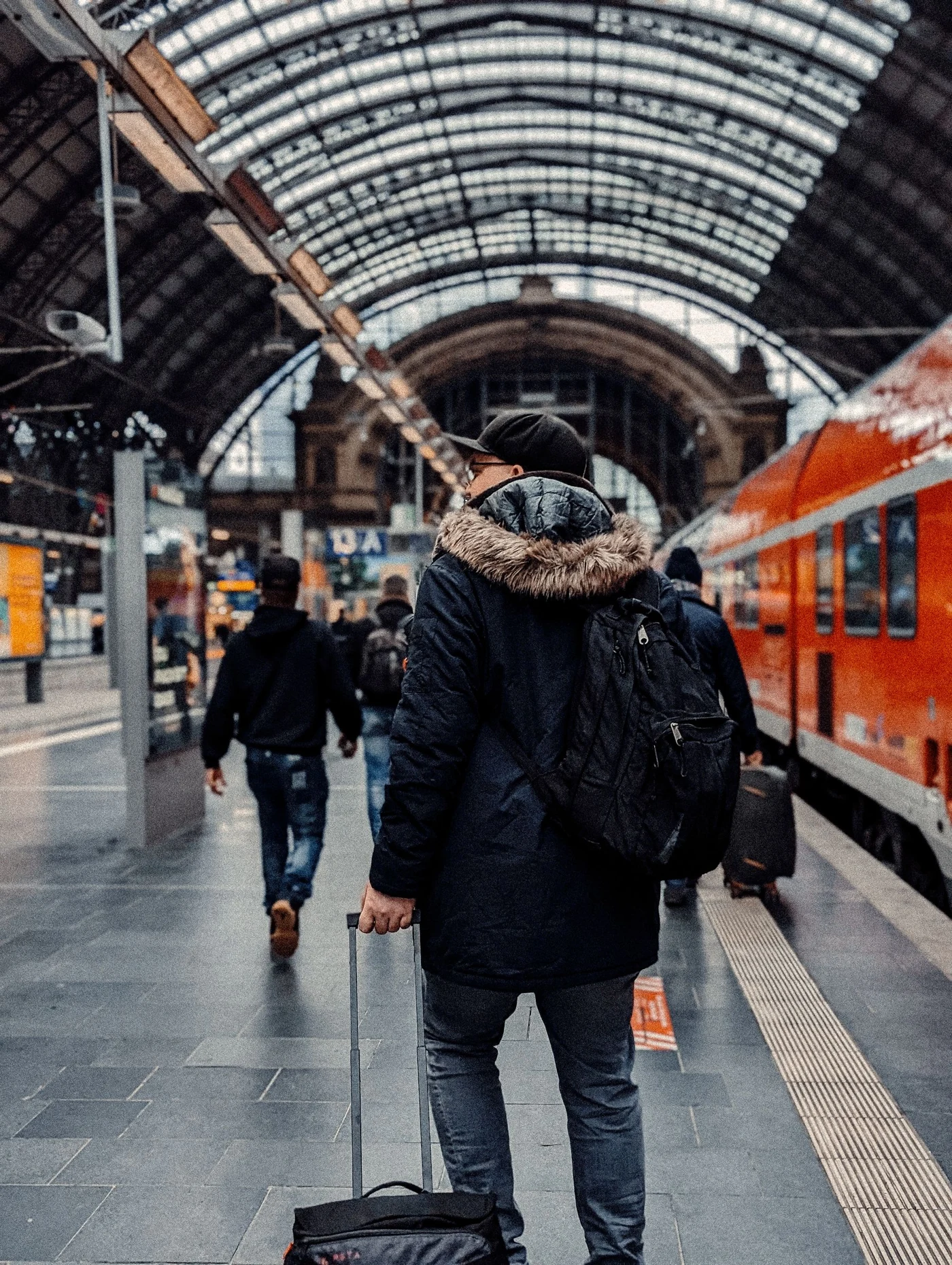 A traveller with a backpack and suitcase on a platform at Frankfurt station